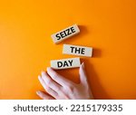 Small photo of Seize the day symbol. Wooden blocks with words Seize the day. Beautiful orange background. Businessman hand. Business and Seize the day concept. Copy space.