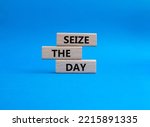 Small photo of Seize the day symbol. Wooden blocks with words Seize the day. Beautiful blue background. Business and Seize the day concept. Copy space.
