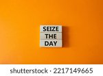 Small photo of Seize the day symbol. Wooden blocks with words Seize the day. Beautiful orange background. Business and Seize the day concept. Copy space.