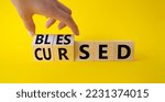 Small photo of Blessed vs Cursed word symbol. Businessman Hand turns cubes with word Cursed and changes it to word Blessed. Beautiful yellow background. Religious and Blessed vs Cursed concept