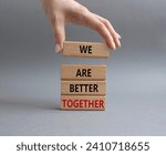We are better together symbol. Wooden blocks with words We are better together. Beautiful grey background. Businessman hand. We are better together concept. Copy space.