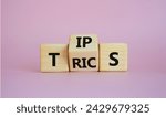 Small photo of Tips and Tricks symbol. Wooden cubes with words Tricks and Tips. Beautiful pink background. Business and Tips and Tricks concept. Copy space