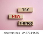 Small photo of Try new Things symbol. Concept words Try new Things on wooden blocks. Beautiful pink background. Business and Try new Things concept. Copy space.
