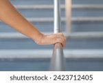 Close up shoot on a hand catching a stair rail. Woman aware about safety while walking on the stair way. Walking up or go down.