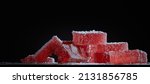 Small photo of Bright red marmalade jelly candy's on black background . Dessert marmalade in the form of rectangulars sprinkled with sugar . The sweetness of berry jelly candy