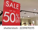 Sale up to 50% off text on a display board stand inside a popular clothing store during year end season sale
