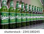 Small photo of PENANG, MALAYSIA - 3 JUNE 2023: A row of Carlsberg's beer bottles display on food truck stall at a outdoor birthday party. Carlsberg is a Danish multinational brewer.