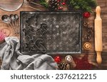 A baking tray with some christmas cookie cutters and copy space, surrounded by christmas decorations. Bakery background.