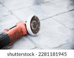 used electrical angle grinder on gray cement floor, famous construction hand tool machine