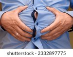 Small photo of Abdominal bloating, big male belly held in hands