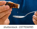 Small photo of Essential oil instilled from a bottle onto a spoon