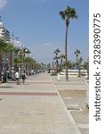 Small photo of Larnaca, CY - September 15th 2022 View down Larnaca, Finikoudes strip in the summer with people enjoying the beach and the love bus, sightseeing tour