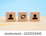 Small photo of Agreement deal concept between two people represented on wooden blocks on blue background with copy space. business closure, empathy, deal closure