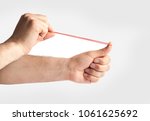 Hands stretching a rubber band as to shoot it, isolated on a white background