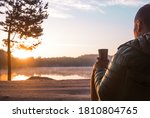 Businessman sitting on a lake with cup of coffee. Morning and sunrise on beautiful nature. Lake and mountains. happy man. inspiration concept, enjoy life. Calm and peace.