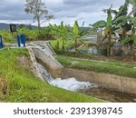 Small photo of Water flows through the floodgate in the irrigation canal. The water come from reservoir through rivers and irrigation ditches to irrigate rice fields, to solve the drought. Irrigation system.