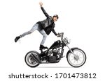 Young daredevil standing on the seat and riding a chopper motorbike isolated on white background