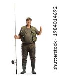 Small photo of Full length portrait of a fisherman in a uniform standing with a fishing rod and showing thumbs up isolated on white background