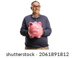Mature man holding a pink piggy bank and smiling isolated on white background