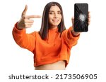 Young female pointing at a smartphone with broken screen isolated on white background