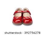 Pair of childs shiny red patent leather shoe with bow design and strap shot at a 3/4 angle on a white background