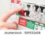 A finger is about to switch off a large red MAINS switch on an RCD circuit breaker board