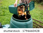 A woman emptying a home composting bin into an outdoor compost bin to reduce waste