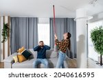 Young couple stares at the ceiling and yells because a neighbor upstairs is having a party with loud music or renovating an apartment and workers are drilling with heavy tools. Nise pollution concept