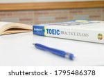 Small photo of NAKHON RATCHASIMA, THAILAND- August 9, 2020: Barron's Toeic book on white table with textbook and pen in classroom