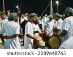 Small photo of Doha, Qatar - November 26, 2022: Omani men practice the Omani art of Razha in their traditional dress and drums.