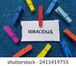 Small photo of Voracious writting on paper background.