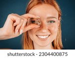 Close-up portrait of smiling woman covering her eye, looking through Omega 3 fish oil capsule. Beautiful girl - healthcare and medical concept