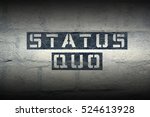 Small photo of status quo stencil print on the grunge white brick wall