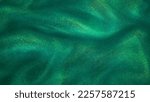 Small photo of Various stains and overflows of gold particles in green fluid with depth of sharpness. Golden particles dust and smooth defocused background. Liquid iridescent shiny backdrop.