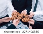 Small photo of Closeup top view businesspeople hand holding gear and join together over meeting table with financial report papers. Cohesive group of office workers holding cog wheel as synergy harmony concept.