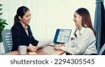 Small photo of Two asian women conduct job interview in office. Applicants wear formal suit while talking about her CV and job application. Interviewer ask inquiry in positive and conversational manner. Enthusiastic