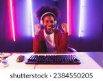 Gaming streamer, African girl playing online fighting with Esport skilled team wearing headphones in neon color lighting room. Talking other players planing strategies to win competitors. Tastemaker.