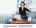 Small photo of Young happy woman buy product by online shopping at home while ordering items from the internet with credit card online payment system protected by utmost cyber security from online store platform
