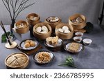 Small photo of The Arrangment of various dim sum in bamboo steamer with chinese bun, pao, bao zi, steamed dumpling, shumai on table in chinese restaurant. Hongkong dim sum or chinese dim sum.