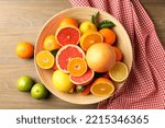 Different citrus fruits on wooden table, top view