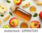 Homemade apple vinegar and ingredients on white background