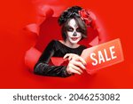 Girl with creative sugar skull makeup with wreath of flowers on head,  isolated red paper hole background. Concept Dia De Los Muertos poster for Halloween party or La Calavera Catrina. Holiday sale.