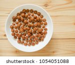 Chocolate cereal balls with milk in a bowl on wooden background. Healthy breakfast concept. Top view. Copy space.