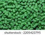 Small photo of Close-up of light green plastic polymer granules. polymer plastic. compound polymer. PVC resin compounds. Tinted plastic granulate for injection moulding process