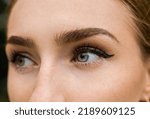 Close-up portrait of a beautiful girl with blue eyes, bushy eyebrows and arrows. 