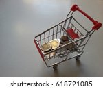Business concept - Thai Baht coins in mini supermarket shopping cart on white background