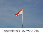 Small photo of Pontianak Indonesia, March 22, 2023, the red and white flag flutters mightily in the clear blue sky. Red and white is the national flag of Indonesia