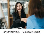 Small photo of Portrait young Asian woman interviewer and interviewee shaking hands for a job interview .Business people handshake in modern office. Greeting deal concept