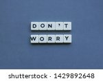 ' Don't Worry ' word made of square letter word on grey background.
