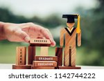 Back to School Concept, People Sign wood with Graduation celebrating cap on wooden square blocks tower blur hands. Space for letter e.g education, graduate, learn. Ideas for international Educational
